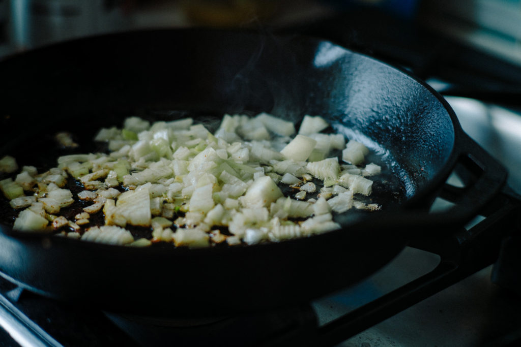 onions sautéing in a cast iron pan