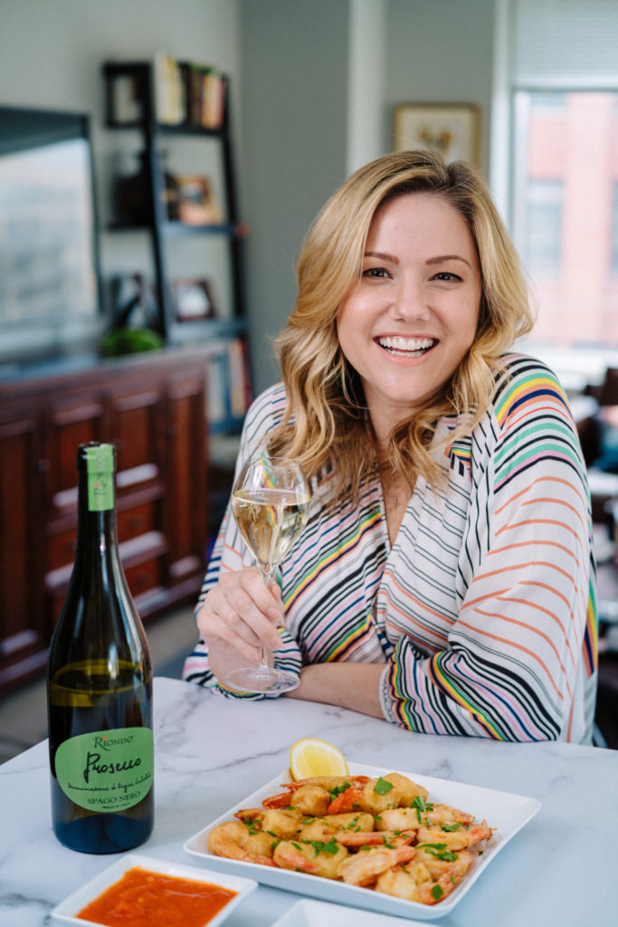 Jaymee Sire poses with fried shrimp and Riondo Prosecco